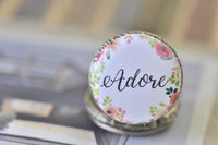 Close-up of 'Adore' pocket watch pendant with hand-painted pink and green florals