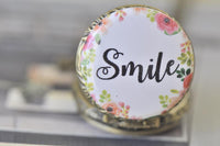 Close-up of the floral 'Smile' pocket watch pendant lid with pink and coral flower detailing