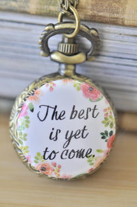 Bronze pocket watch necklace with floral wreath and 'The best is yet to come' quote pendant