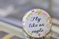 Close-up of Fly Like an Eagle quote pendant cover with pink and green floral wreath detail