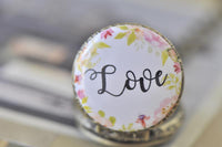 Close-up of the Love pocket watch pendant with pink and green floral wreath design