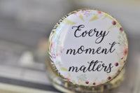 Close-up of the "Every moment matters" floral quote artwork inside the pocket watch pendant