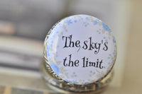 Close-up of pocket watch pendant lid with blue floral design and motivational quote