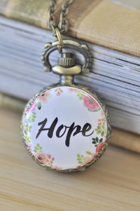 Antique bronze pocket watch necklace with Hope script surrounded by a floral wreath design