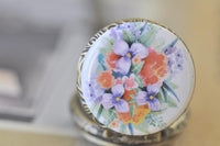 Close-up of the watercolour flower artwork on the pocket watch pendant lid