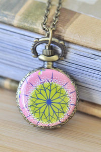 Antique bronze pocket watch necklace with a pink and green mandala kaleidoscope design