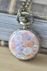 Pocket watch necklace with pink Japanese sakura floral artwork on the case front