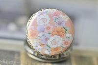 Close-up of pink sakura floral pocket watch pendant with delicate blossom design