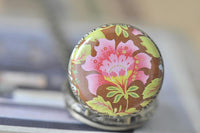 Close-up of pink, yellow and green floral pocket watch pendant design