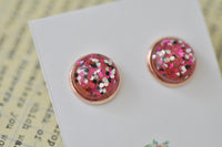 Close-up angled view of glitter resin stud earring showing rose gold rim and sparkle detail