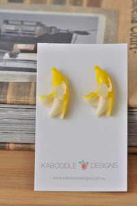 Pair of yellow resin banana stud earrings on a white Kaboodle Designs card