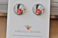 Round stud earrings with tropical flower and girl artwork, red dress and green ferns