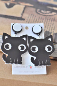 Black perspex kitten drop earrings on white and black display card with round stud tops