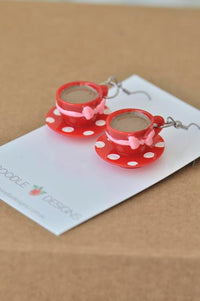 Red polkadot resin teacup earrings with pink bow detail on white backing card