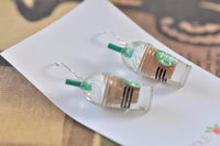 Side angle of both frappe coffee earrings lying flat showing coffee layers