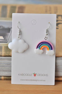 Mismatched resin earrings on card: white cloud and pastel rainbow with cloud base