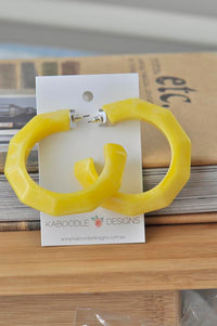 Yellow faceted acrylic hoop earrings displayed on Kaboodle Designs card