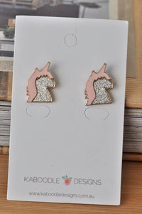 Pair of pink and silver glitter unicorn stud earrings on Kaboodle Designs card