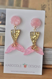 Pink and gold glitter mermaid tail dangle earrings on Kaboodle Designs card, front view