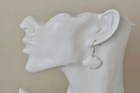Side view of white cloud-shaped resin earring worn on ear