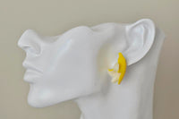 Banana stud earring shown worn on ear, close-up side view