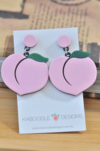 Pink perspex peach drop earrings with green leaf detail on Kaboodle Designs card