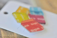 Close-up of the Sugus lolly wrapper brooch showing glossy acrylic finish and printed branding
