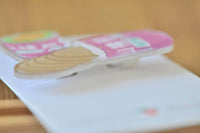Close-up side angle of acrylic Haw Flakes brooch showing glossy finish and layered shape