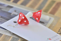 Close-up of glossy resin toadstool earring showing stainless steel hook and stem detail