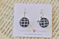 Round dangle earrings with purple and green striped pattern on white display card