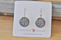 Round dangle earrings with grey raindrop print in blue, pink and mint on a Kaboodle Designs card