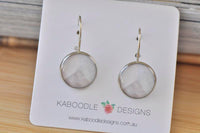 Round alloy dangle earrings with grey and white geometric pattern on card backing