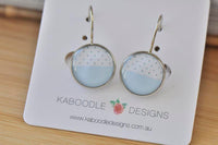 Round polkadot dangle earrings on card, showing silver-tone setting and lever-back hooks
