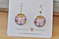 Round geometric dangle earrings on card with yellow, pink, purple and teal patchwork design