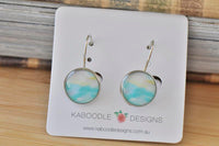 Round watercolour dangle earrings in aqua and cream on a Kaboodle Designs display card