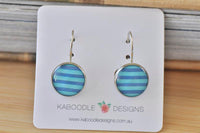 Round blue and white striped dangle earrings on Kaboodle Designs display card