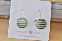 Round black, white and gold striped dangle earrings on Kaboodle Designs display card