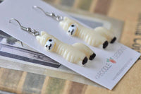 Beige llama drop earrings lying flat on backing card showing textured coat detail