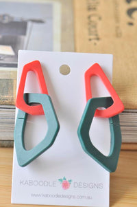 Red and teal geometric resin drop earrings on Kaboodle Designs display card