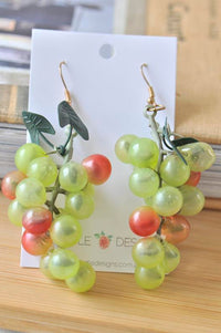 Green and red plastic grape cluster drop earrings on a Kaboodle Designs display card