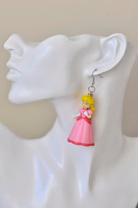 Princess Peach drop earring worn on a model's ear, side view showing full figure detail