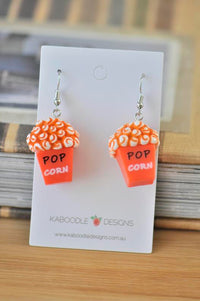 Pair of orange and white resin popcorn box earrings on Kaboodle Designs card