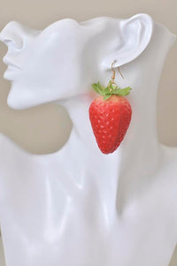 Single large strawberry earring worn on white mannequin ear, shown from the side