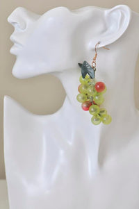 Grape cluster earring worn on ear, showing scale against a mannequin head