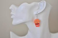 Single popcorn box earring shown worn on model's ear for scale