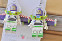 Close-up of space ranger earrings on card showing spacesuit and boot detail