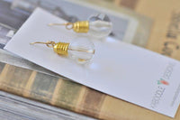 Pair of glass-effect lightbulb drop earrings resting on Kaboodle Designs card
