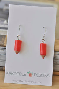 Red resin pencil dangle earrings on a Kaboodle Designs card with stainless steel hooks