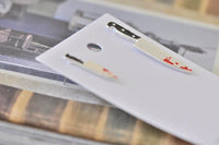 Small and large knife earrings laid flat on white card showing size difference and blood detail