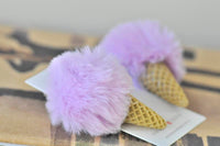 Close-up of two purple fluffy pom pom ice cream earrings with waffle cone detail